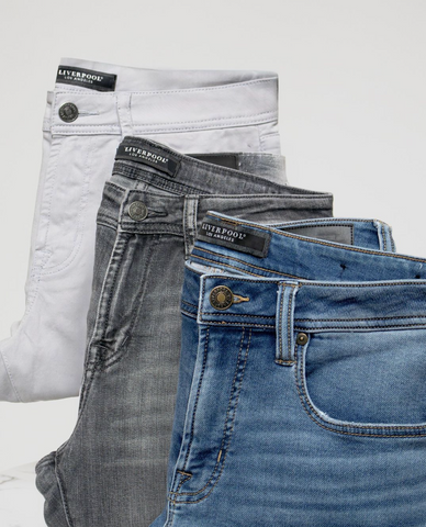White, black, and light-wash jeans (fashion trends 2024) stacked on top of each other
