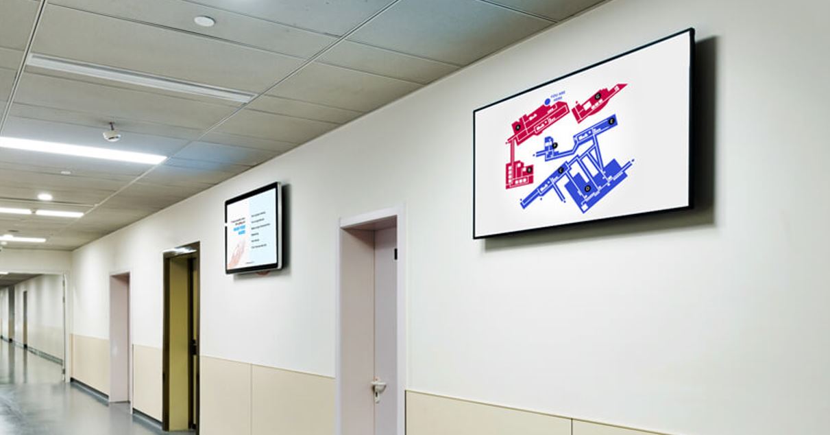 A hospital corridor with LED signage for wayfinding