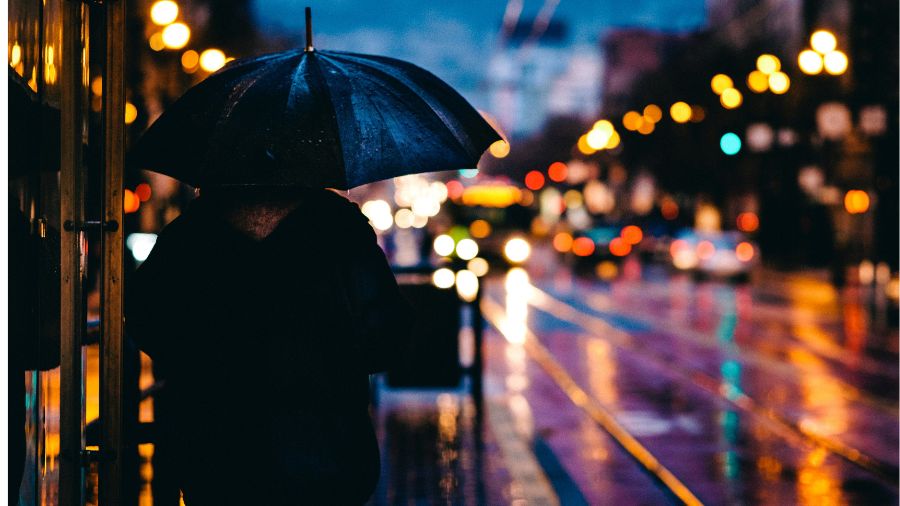 Piéton avec un parapluie nuit pluvieuse