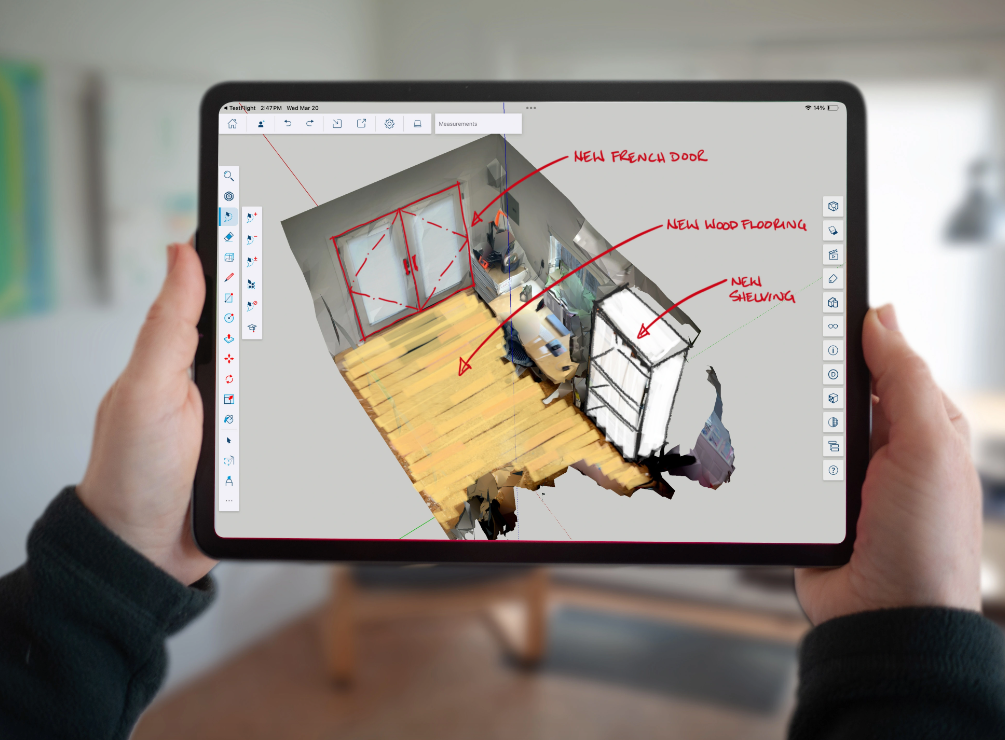 Hands holding an iPad showing a scan with markups and design ideas in SketchUp