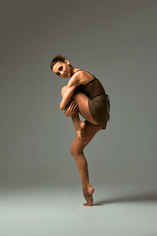 A woman posing in brown stirrup tights.