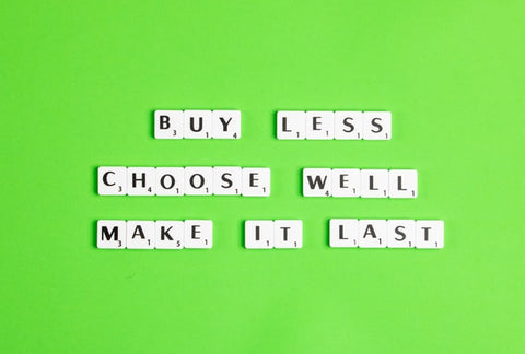 Sign that says buy less, choose well, make it last on a bright green background