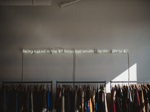 A message on the wall above the clothing rack.