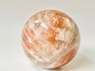 Orange and cream sunstone sphere with sparkly flash