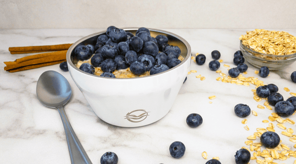 Hot oatmeal topped with blueberries in White Frost Calicle insulated bowl