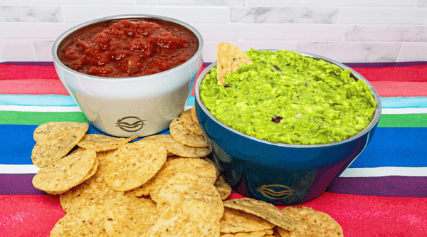 Blue and white Calicle bowls filled with guacamole and salsa with tortilla chips for dipping