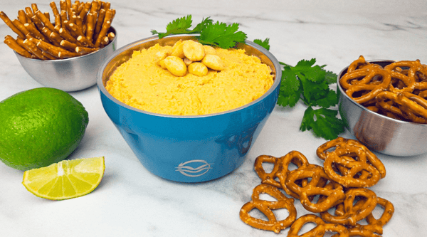 Blue Calicle bowl filled with hummus with pretzels for dipping