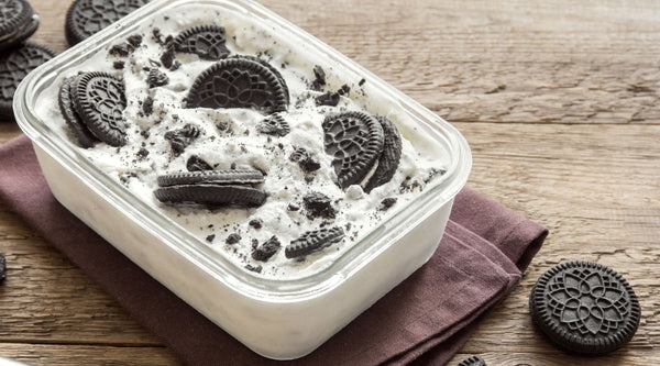 Homemade cookies 'n cream ice cream in a shallow, plastic container for optimal freezing and storage