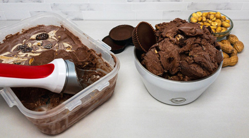 White Calicle insulated bowl filled with no-churn chocolate peanut butter cup ice cream next to a container of ice cream with an ice cream scoop