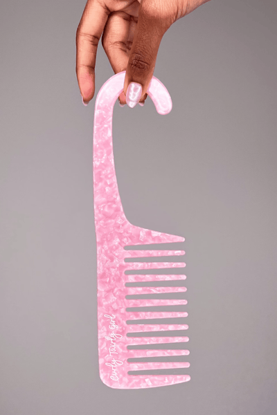 Hand holding pink wide tooth comb with hook