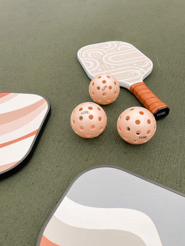 Aesthetic pickleball paddles with pink pickleballs