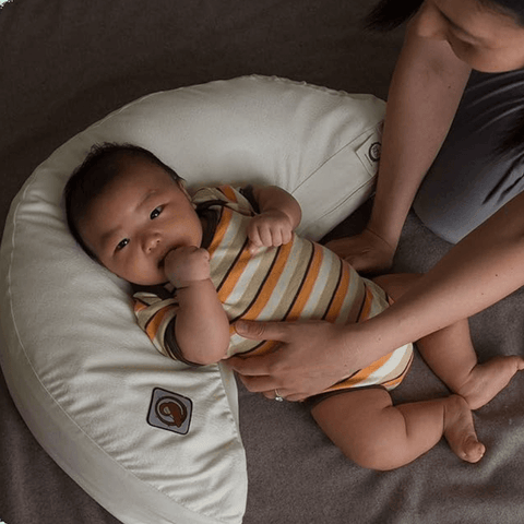 baby laying on organic nursing pillow