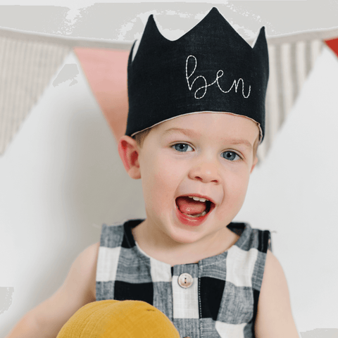 boy wearing black birthday party hat