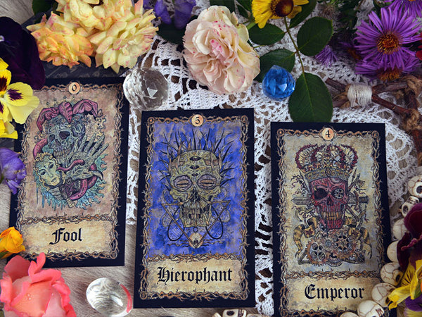 A tarot card pull in a past, present, future tarot spread. The hierophant, fool and emperor are visible in the images.