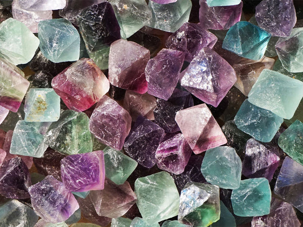 Rough tumbled stones of green purple and blue Fluorite are pictured, believed to improve your spiritual wellbeing.