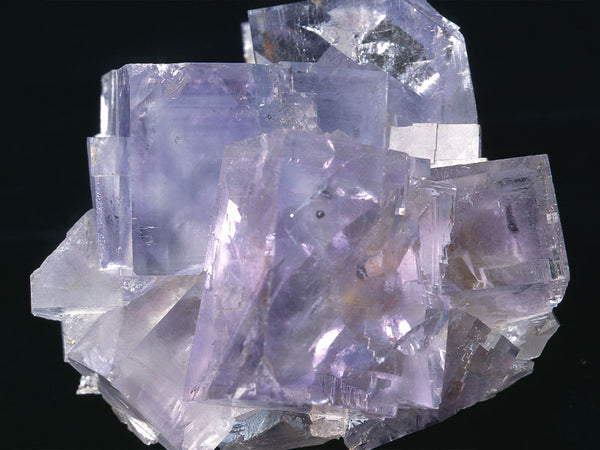 A Purple Fluorite stone is picture and is associated with the solar plexus chakra and positive energy.