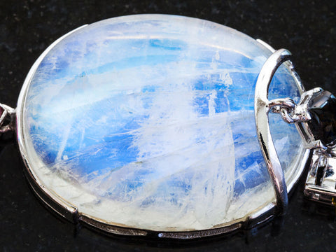 A closeup of a rainbow moonstones necklace pendant, said to enhance inner vision