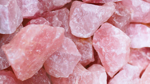 Raw specimens of Rose Quartz meaning love are displayed.