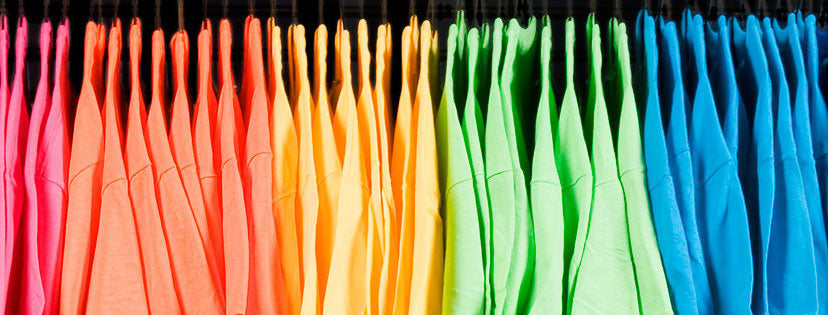 Email BONZi Shirts for custom print shirt and apparel designs. Stock image rack of multicolored t-shirts.