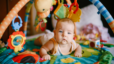 baby playing on baby gym