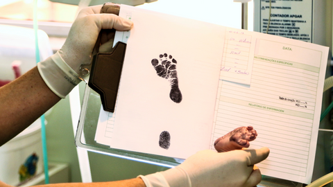 doctor placing baby's feet on baby book to create a footprint
