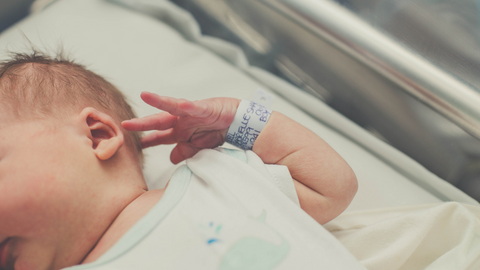 newborn baby with hospital wristband