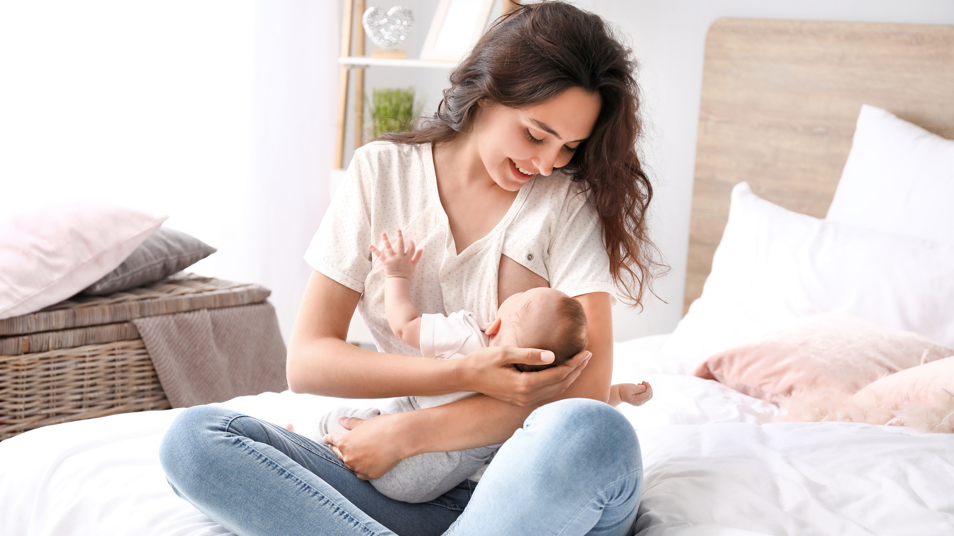 mom sitting on bed breastfeeding baby