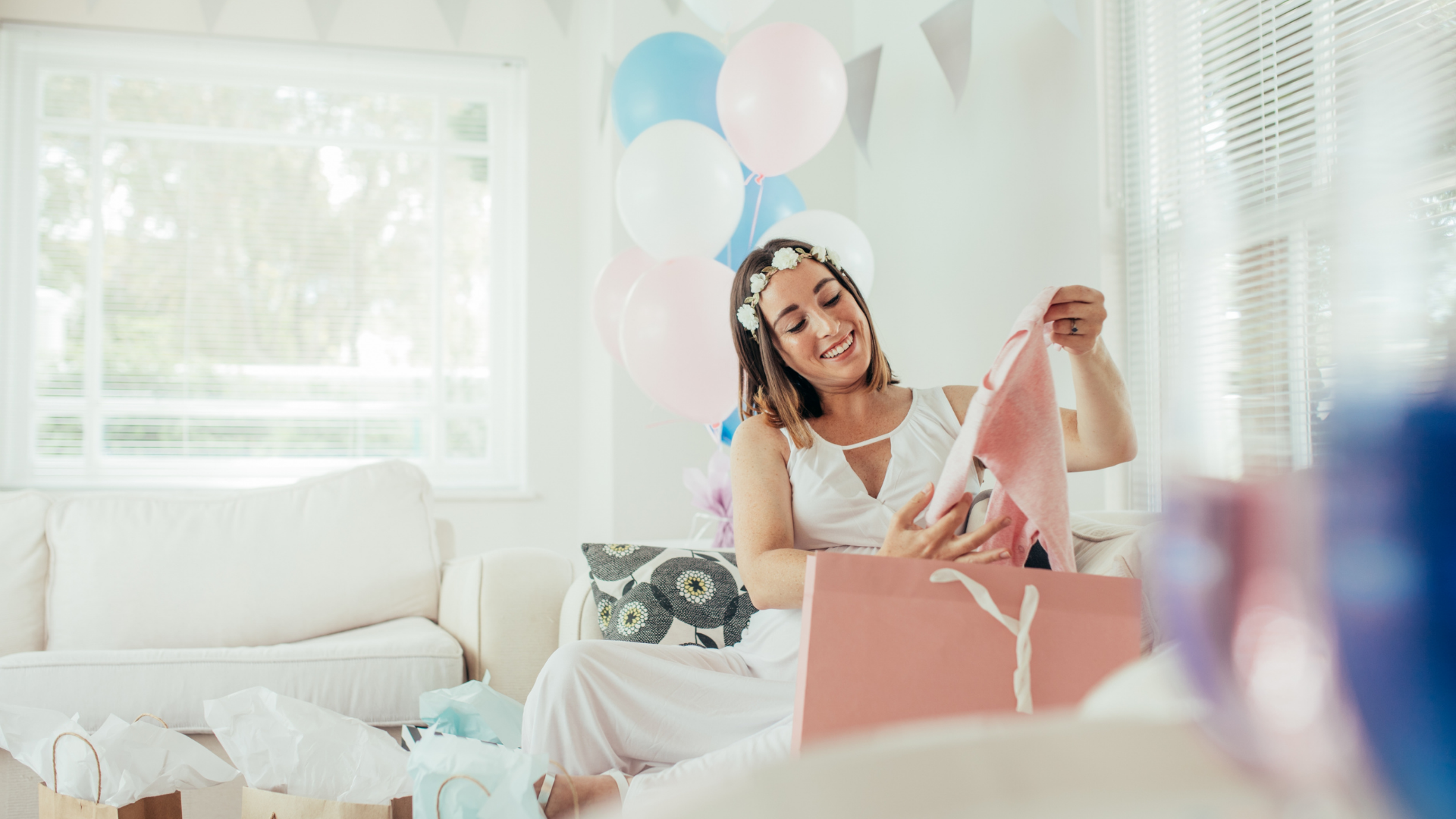 pregnant lady unwrapping baby shower gifts