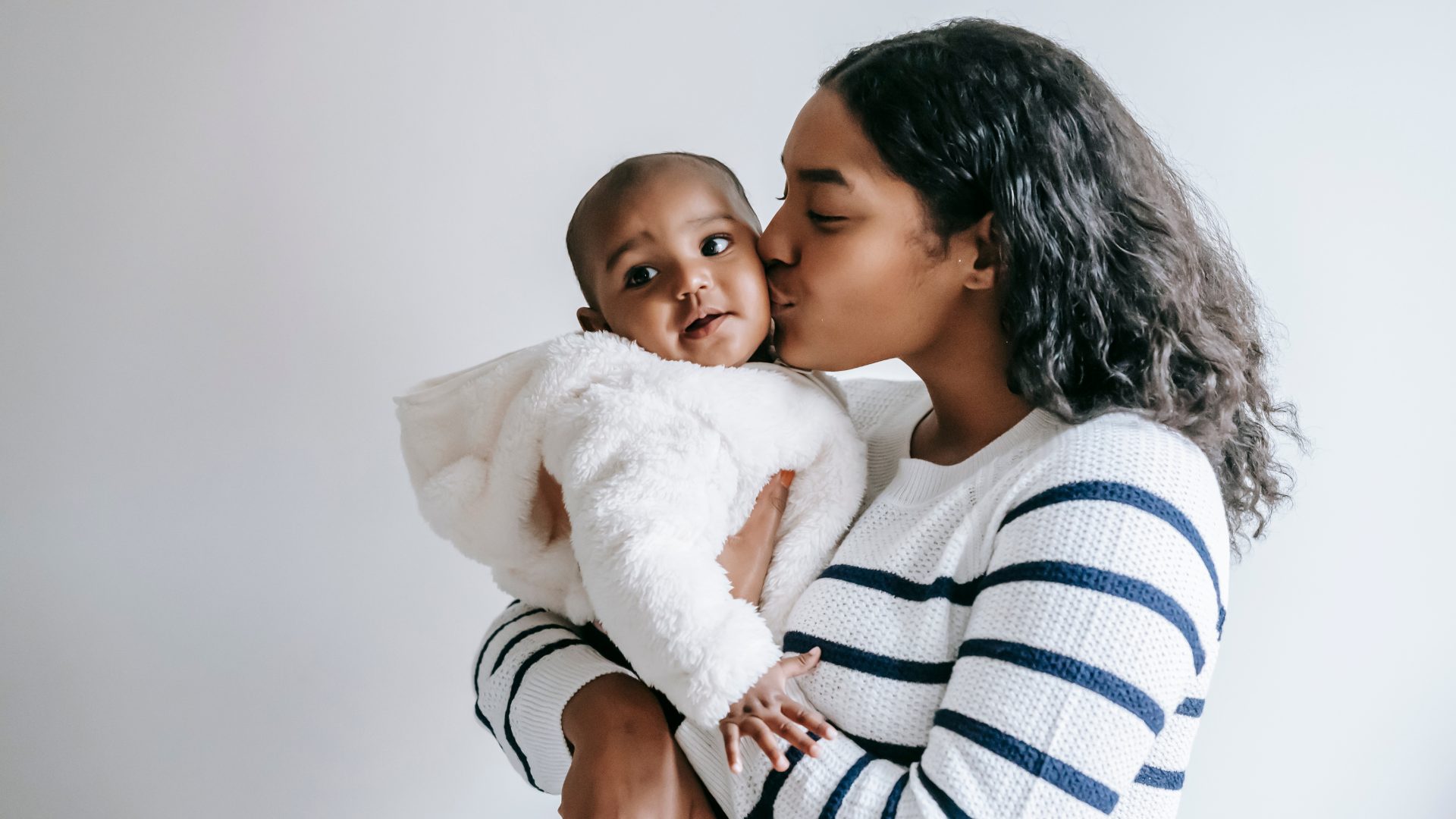 mom kissing baby at baby photoshoot