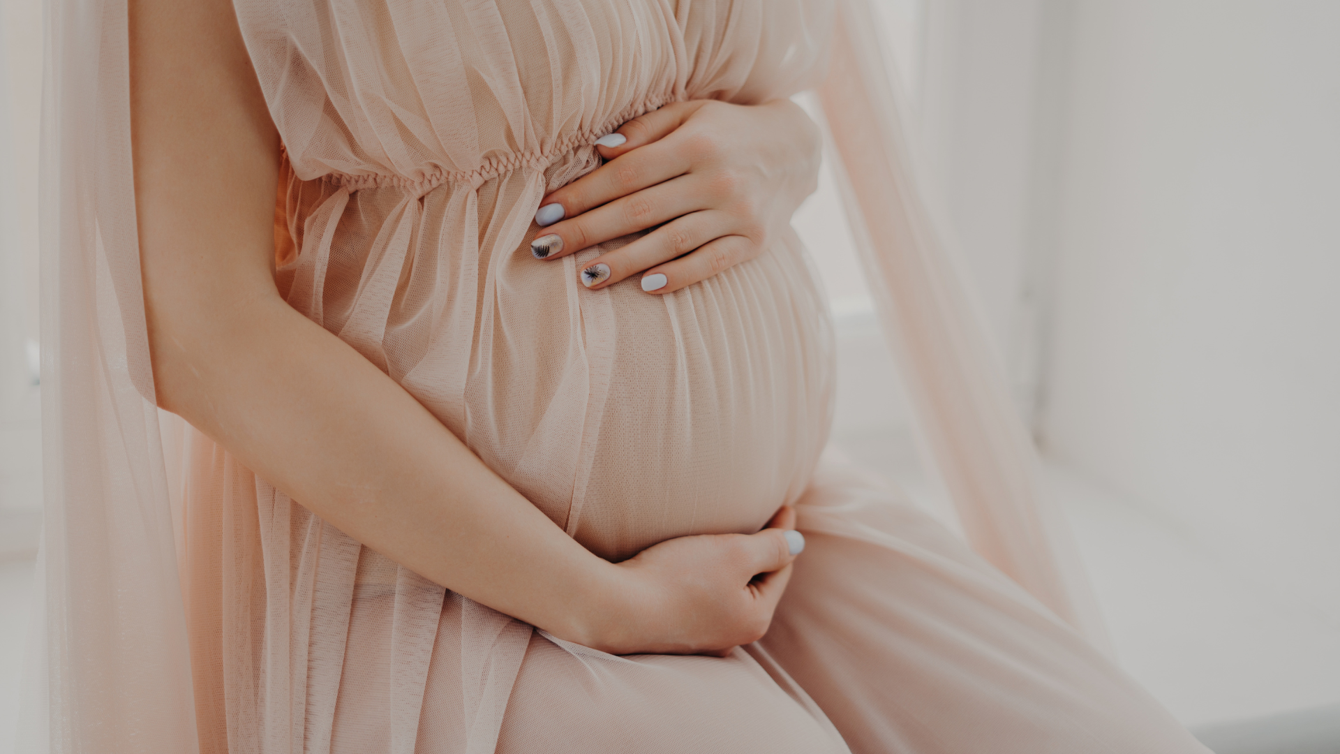 pregnant woman wearing a pink dress for baby shower