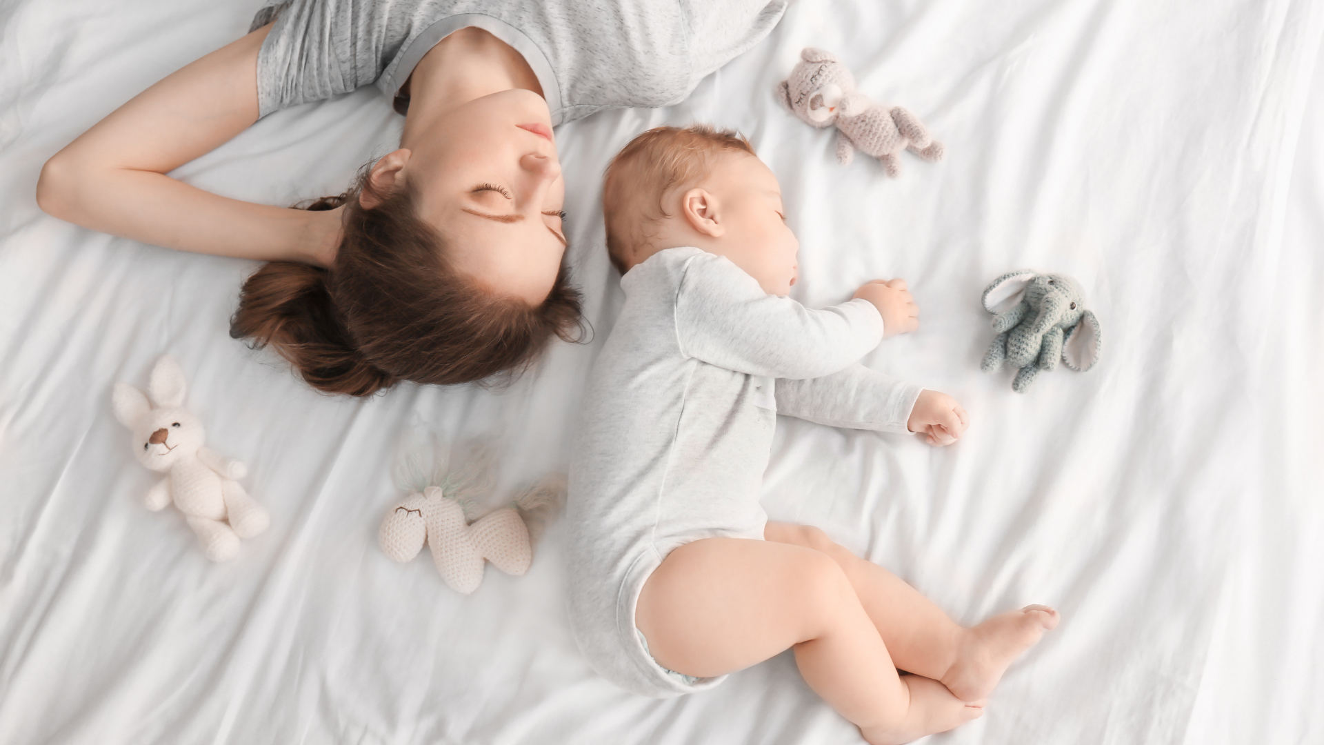 mom and baby sleeping on bed