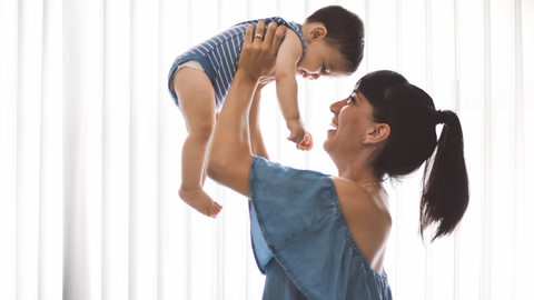 mom picking up baby and smiling