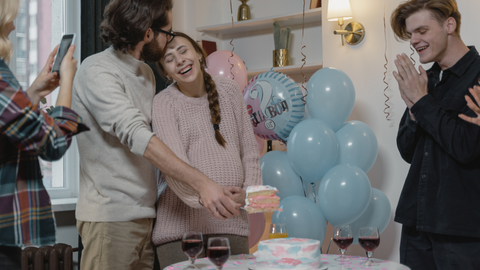 mum and dad to be cutting gender reveal cake