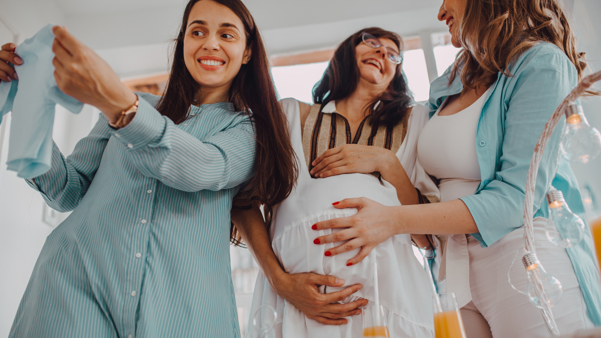 friends looking at cute onesie at baby shower