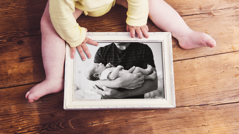 baby holding newborn photo frame