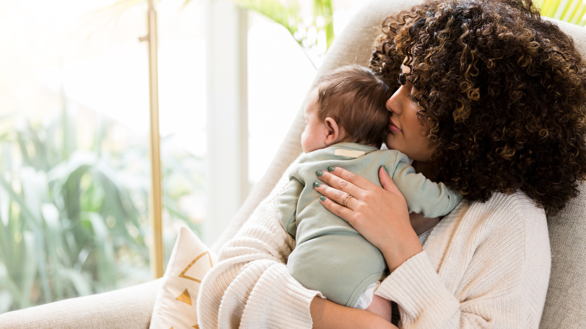 mom holding baby on couch