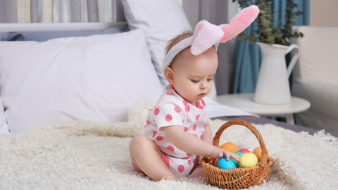 baby playing with first easter basket wearing bunny ears