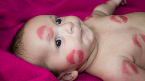 baby's first valentines day photoshoot with kisses on face