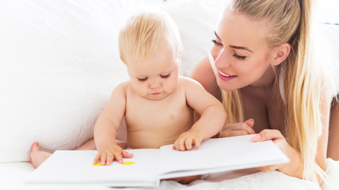 mom and baby looking at paper baby memory book