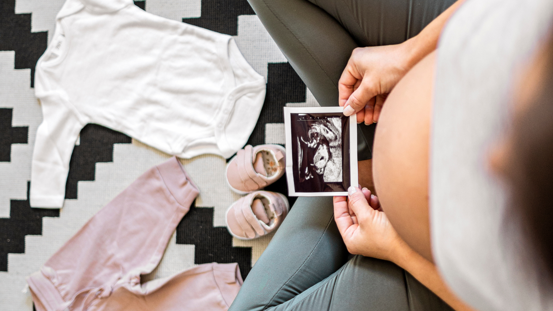 pregnant woman holding ultrasound photo of baby