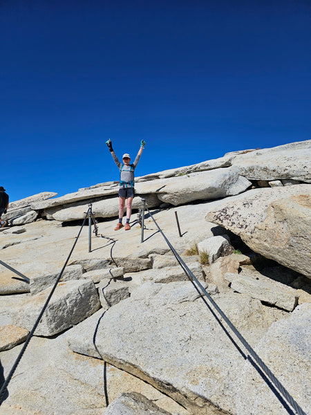 person scaling half dome's cables