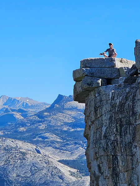 peson enjoying view on top of half dome in yosemite