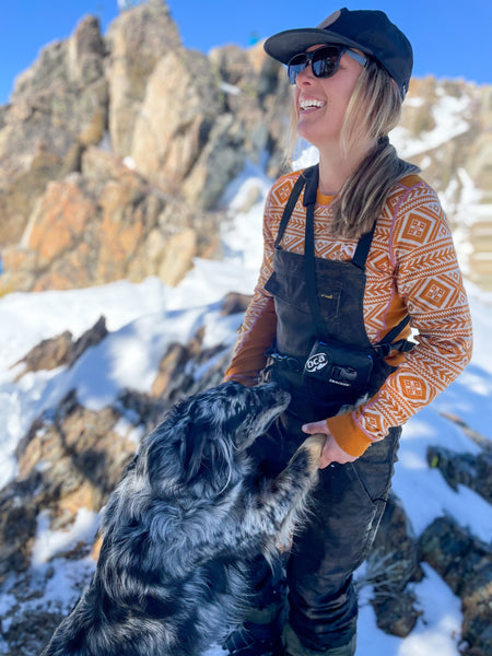 woman with her dog smiling in the snow