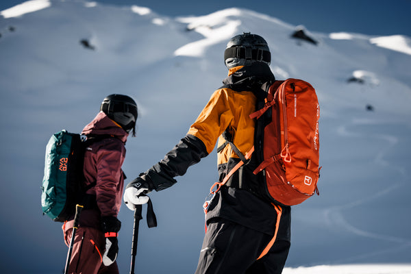 two people skiing with ortovox litric pack