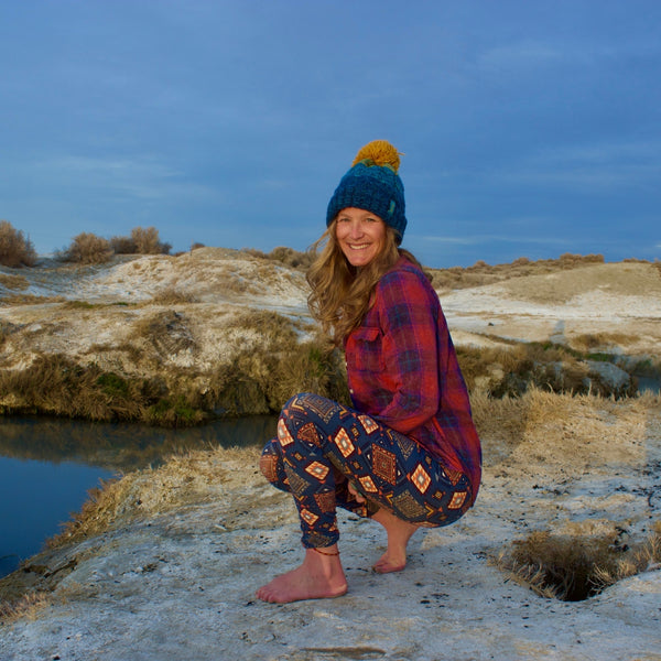 woman kneeling in front of a hot spring