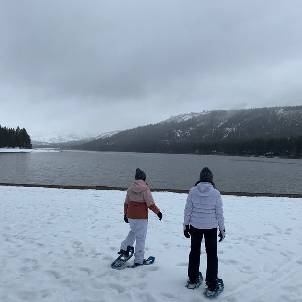 two people snowshoeing at the edge of donner lake