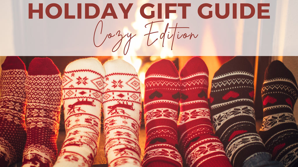 photo of four pairs of feet with holiday socks in front of fireplace