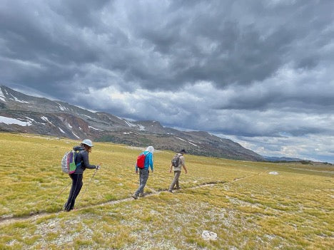 people hiking under cloudy skies