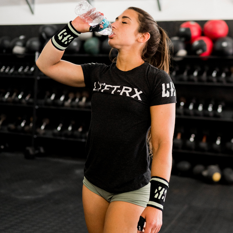 female athlete drinking water in mint sweatbands