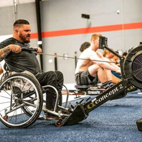 male athlete on wheelchair using rowing machine